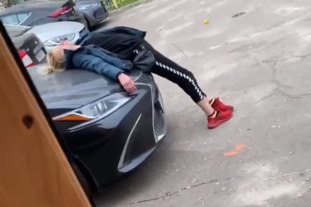 На Оболони женщина уснула на капоте Lexus (видео)