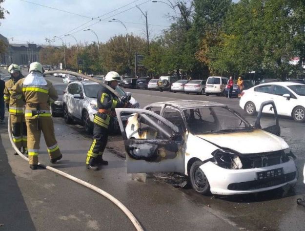 рятувальник гасить пожежу в автівці